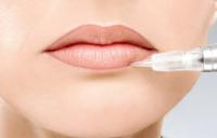 девушке делают перманентный макияж губ
